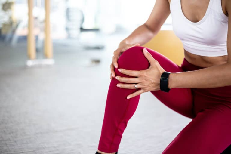 woman holding knee in pain