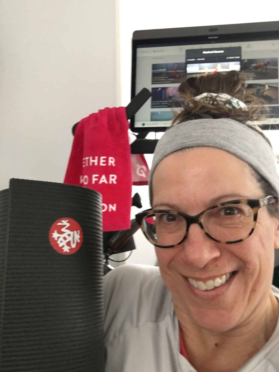 leah with manduka mat in front of peloton bike