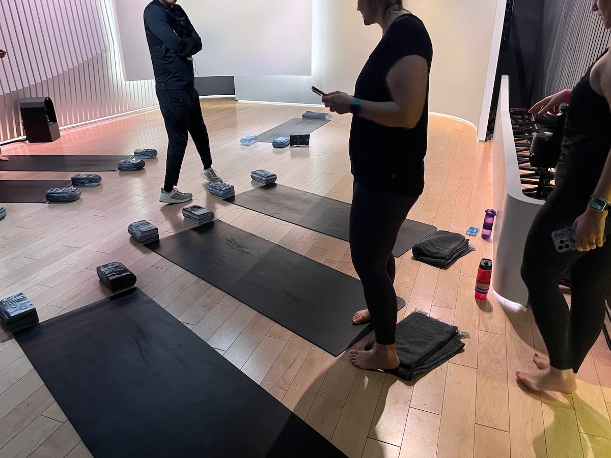 A group of people practicing yoga in a peloton studio.