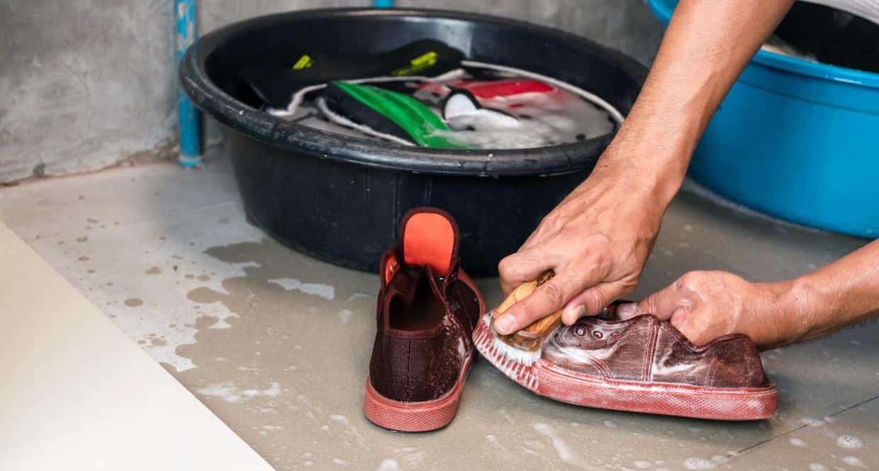 Washing the sneakers with a washing brush and washing powder.