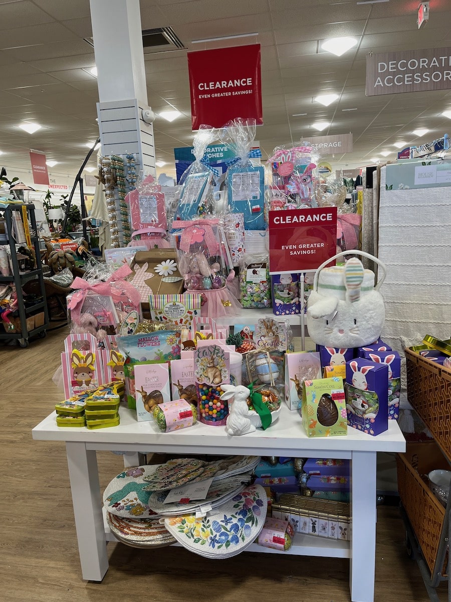 A variety of easter-themed decorations and items displayed on a store shelf with an "after easter sales" sign overhead.